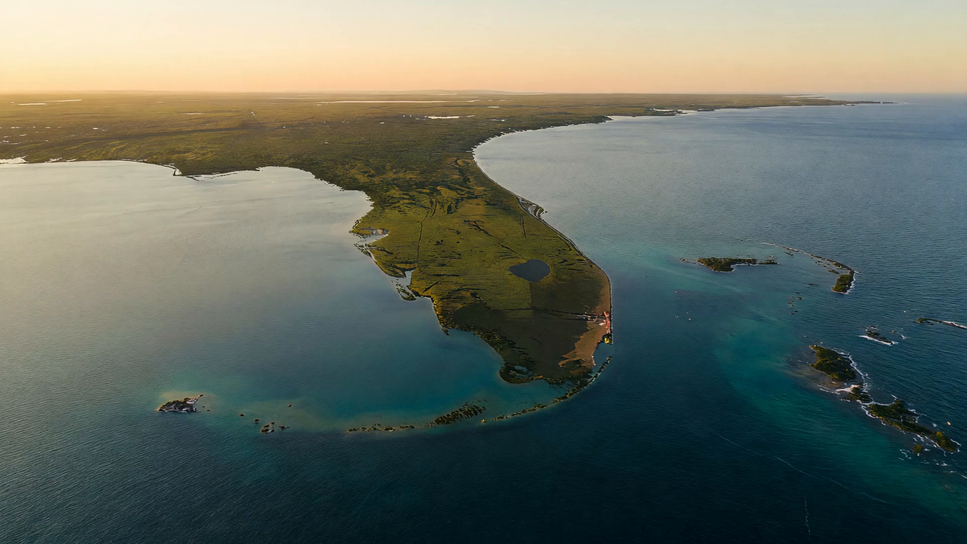 Editorial aerial render derived from developer materials of the Florida peninsula and the Gulf of Mexico at golden hour — two coasts, no labels, no people.